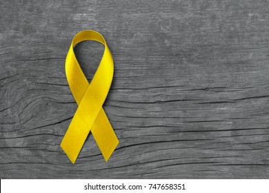 Yellow Ribbon Symbolic For Sarcoma Bone Cancer, Spina Bifida Awareness Month And Suicide Prevention On Helping Hand