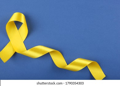 yellow ribbon symbolizing cancer in children top view
