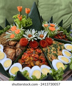 Yellow rice tumpeng as Javanese traditional dishes with friedchicken, noodle, egg and urap vegetable with beautiful garnish
