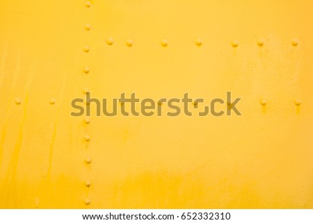 Yellow riveted metal surface background