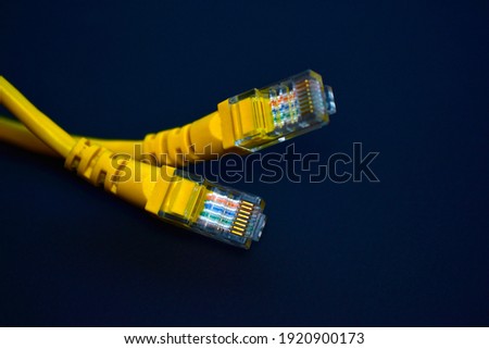 Yellow RJ-45 or ethernet internet cable on black background