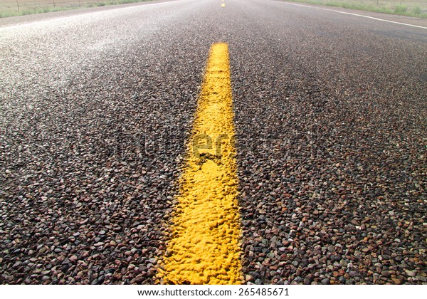 Yellow road dividing\
line on a desert road