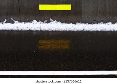 Yellow Road Reflector On The Road With Snow Line.