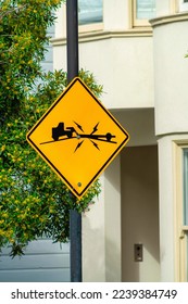 Yellow road sign with black paint in the city that depicts a warning for trailers given a the steep slopping hills. Sign appears in San Francisco showing how steep grade can break trailer hitches. - Shutterstock ID 2239384749