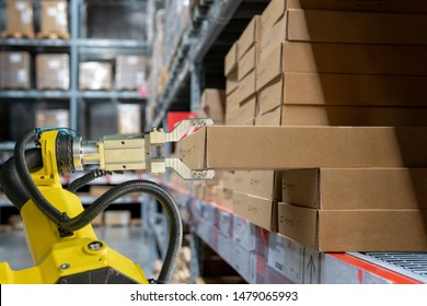 yellow robotic arm carry cardboard box in warehouse - Shutterstock ID 1479065993