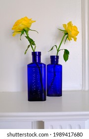 Yellow roses in cobalt blue victorian medicine bottles - Shutterstock ID 1989417680