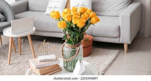 Yellow roses in vase and books on table in living room - Powered by Shutterstock