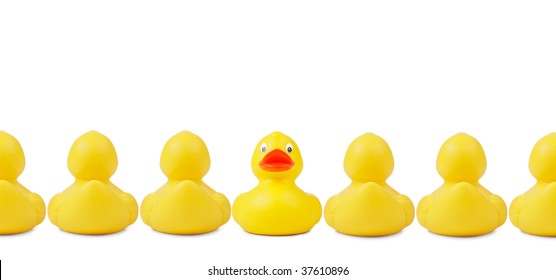 Yellow Rubber Ducks In A Row. An Individalist Is Sticking Out The Crowd. Clipping Path Included.