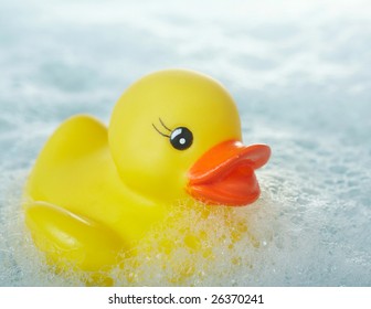 Yellow Rubber Ducky Floating In Soapy Water