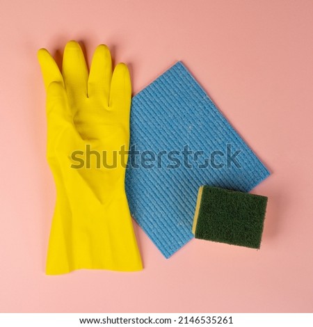 a yellow rubber glove and two cleaning sponges