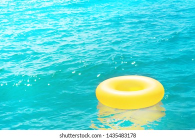 A Yellow Rubber Ring Floats In The Crystal Blue Sea In Summer