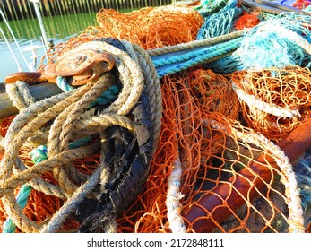 Yellow, Rusty And Blue Mooring Lines. Fishing Nets, Fishing Industry, Old Rope And Rusty Metal Pulley System Part On Fishing Boat