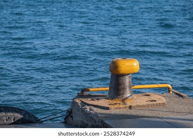 yellow rusty bollard on the quay. passenger ferry pier. sea in the background. - Powered by Shutterstock