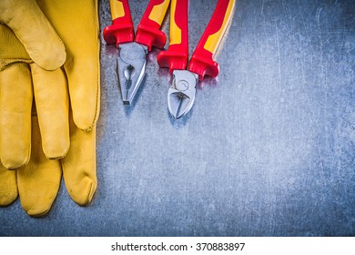 Yellow safety gloves pliers wire-cutter on metallic background electricity concept. - Shutterstock ID 370883897