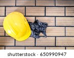 Yellow safety helmet and dirty glove on brown brick floor with copy space and window light