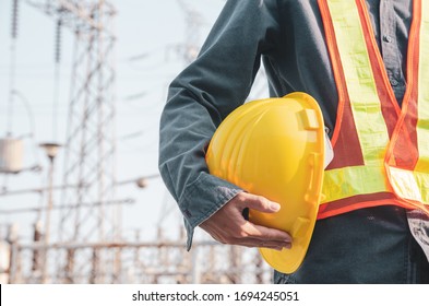 Yellow safety helmet is in the hands of an electrician. - Shutterstock ID 1694245051