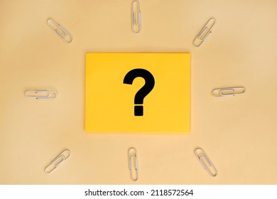 Yellow sheet for notes with a question mark on a yellow background and paper clips
