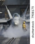 A "Yellow Shirt" Aircraft Director in Front of an F/A-18F Super Hornet Aboard the Nuclear Aircraft Carrier, USS Enterprise