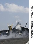 A "Yellow Shirt" Aircraft Director Taxis an F/A-18F Super Hornet onto a Catapult Aboard the Nuclear Aircraft Carrier, USS Enterprise