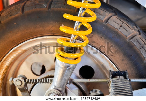 Yellow shock\
absorber for the back of the motorcycle.\
Yellow shock absorber\
part is part of the\
motorcycle.