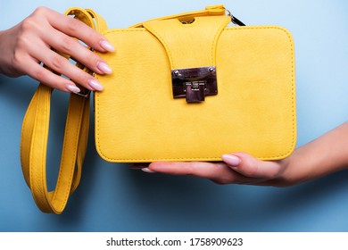 A Yellow Shoulder Bag In Female Hands. Photo Of A Yellow Clutch Bag.