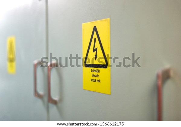 Yellow sigh danger electric\
shock with lightning in triangle on a metal electric distribution\
box. 
