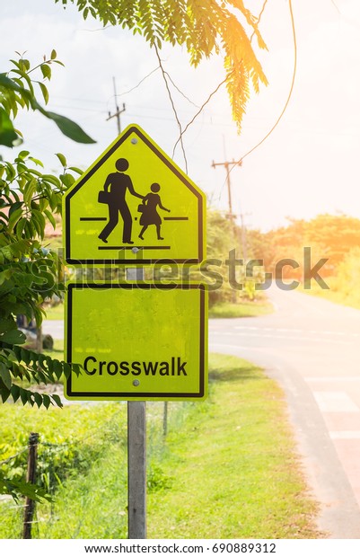 Yellow sign crosswalk at school zone symbol in the\
countryside .