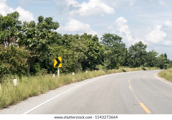 Yellow sign with\
curved arrow and\
road,Thailand