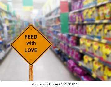 Yellow Sign With Message FEED WITH LOVE And Blur Image Of Pet Food Aisle In Super Market