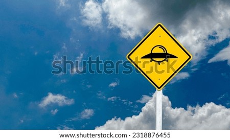 Yellow sign with painting of the UFO with clouds and blue sky in background concept of UFO monitoring