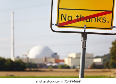 A yellow sign saying No thanks in front of a nuclear power station.