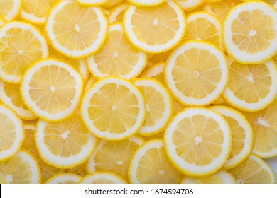 Yellow sliced lemons places on a table overlapping each other. Background texture of fresh yellow fruit. 