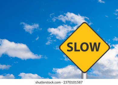 Yellow Slow Sign with Cloudy Sky in the background