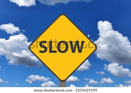 Yellow Slow Sign with Sky in Background