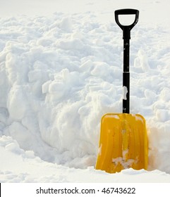 Yellow Snow Shovel Standing In The Snow