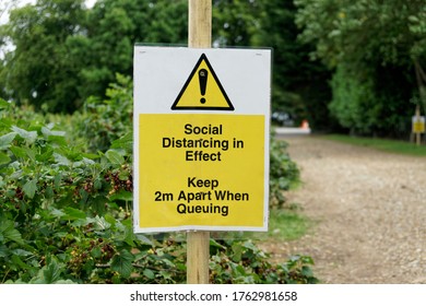 A Yellow Social Distancing In Effect Warning Sign Keep 2m Apart When Queuing, Applied For Summer Fruit Picking In England UK