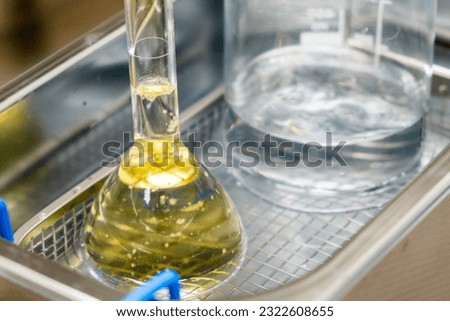 Yellow solution in the flask and beaker for dissolving or extraction into ultrasonic bath. Urea analysis. Clinical, toxicological and forensic analysis.