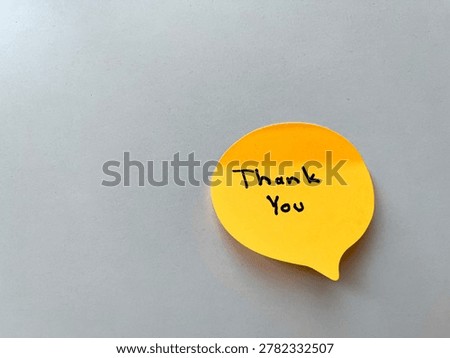 Yellow speech bubble sticky note displaying thank you message, symbolizing gratitude, appreciation, and communication