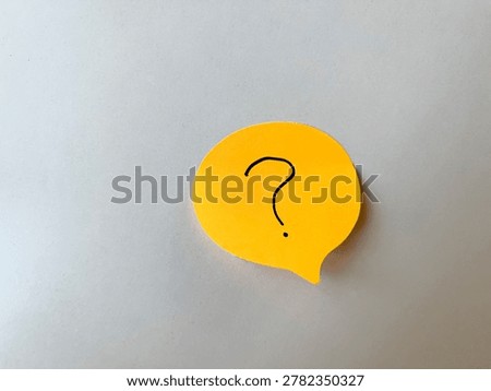 Yellow speech bubble sticky note with a drawn question mark, symbolizing questions, help, uncertainty, and seeking information