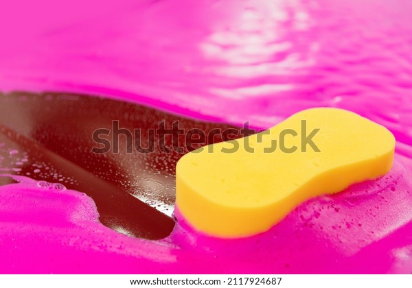 Yellow sponge pink foam clean dirt auto. Concept\
wash car of female.