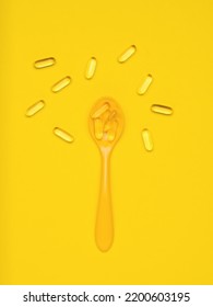 Yellow Spoon And Fish Oil Capsules On A Yellow Background. Biologically Active Additive. Flat Lay.