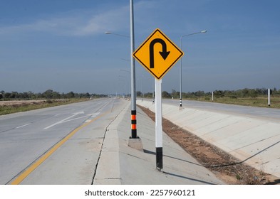 Yellow square sign to u-turn ahead on new concrete road - Shutterstock ID 2257960121