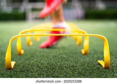 A yellow step-over ladder for speed and leg strength training equipment (Focus), Photo with action of a sport player is training on it as blurred background. Sport object and action photo. - Powered by Shutterstock