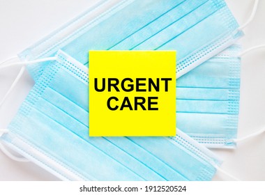 Yellow Sticker With Text Urgent Care Lying On The Masks. Medical Concept