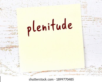 Yellow sticky note on wooden wall with handwritten inscription plenitude - Shutterstock ID 1899770485