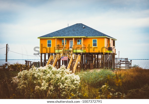 yellow stilt house,\
stilts house Florida