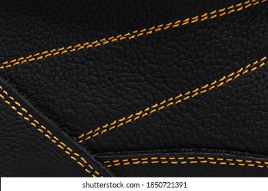 Yellow stitches on the leather of boots. Macro photo.