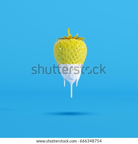 yellow strawberry  dripping with white paint on blue background. minimal idea food.