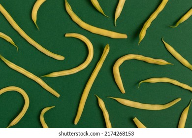Yellow string beans on a green background. Top view.