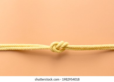 Yellow string knotted on a orange color background